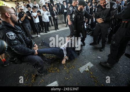 Orthodoxe Juden blockieren Highway gegen Wehrpflicht in Isra BNEI BRAK, ISRAEL - 27. JUNI: Dutzende ultraorthodoxe Juden, auch bekannt als Haredim, stoßen am 27. Juni 2024 mit der israelischen Polizei zusammen, während sie einen Sit-in-Protest gegen den Militärdienst auf der Autobahn in Bnei Brak, Israel, veranstalten. Foto: saeed qaq Copyright: XSAEEDQAQx image00011.jpeg Stockfoto