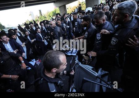 Orthodoxe Juden blockieren Highway gegen Wehrpflicht in Isra BNEI BRAK, ISRAEL - 27. JUNI: Dutzende ultraorthodoxe Juden, auch bekannt als Haredim, stoßen am 27. Juni 2024 mit der israelischen Polizei zusammen, während sie einen Sit-in-Protest gegen den Militärdienst auf der Autobahn in Bnei Brak, Israel, veranstalten. Foto: saeed qaq Copyright: XSAEEDQAQx image00013.jpeg Stockfoto