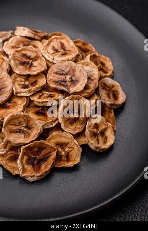 Runde Scheiben süßer Bananen auf dunklem Betonhintergrund Stockfoto