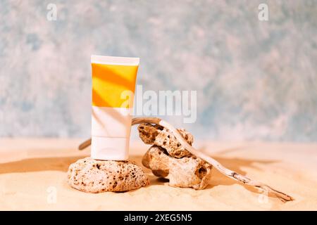 Modellrohre mit Sonnenschutz auf strukturierten Steinen mit Baumwurzel. Ein Podium für kosmetische Produkte mit dem Layout einer leeren Flasche Stockfoto