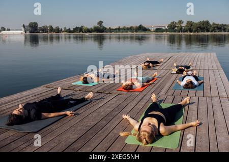 Yoga-Kurs am Morgen mit einem Lehrer am Yachthafen in der Stadt. Stockfoto