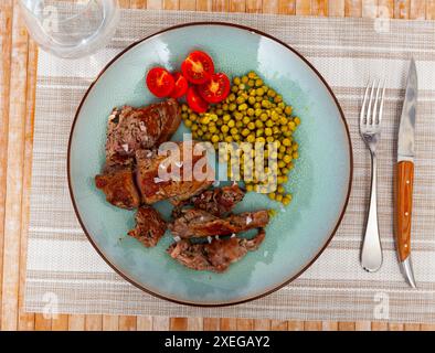 Über offenem Feuer gekochtes Rindfleisch mit appetitlicher Kruste und dunklen Streifen mit Kirschtomaten und Bohnen Stockfoto