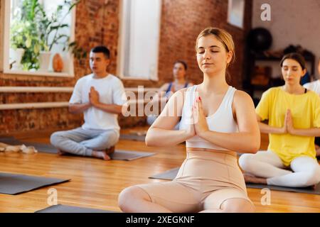 Gruppe von jungen sportlich attraktiven Menschen üben Yoga-Unterricht mit Kursleiter Stockfoto