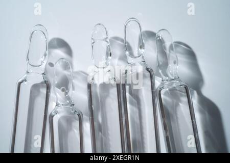 Mehrere Ampullen zur Injektion mit Arzneimitteln auf blauem Hintergrund. Stockfoto