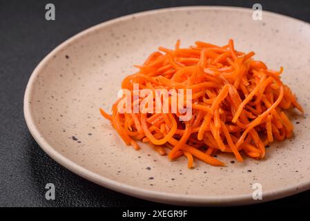 Köstliche scharfe Karotten, geschnitten und gekocht in koreanischer Art auf einer Keramikplatte Stockfoto