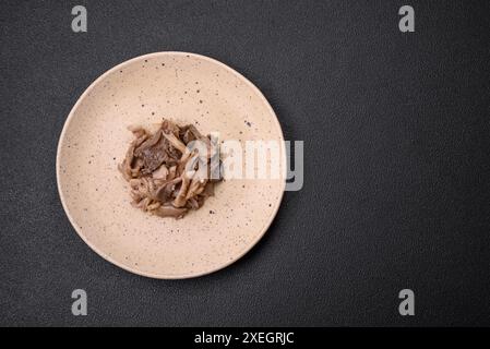 Köstliche scharfe Pilze, geschnitten und gekocht in koreanischer Art auf einer Keramikplatte Stockfoto