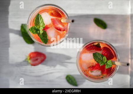 Erfrischender hausgemachter Cocktail mit Erdbeeren und Minze auf dem Tisch in einer hellen Küche. Stockfoto