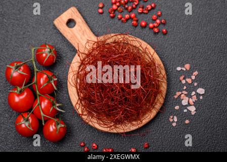 Rote, dünne, heiße Chilifäden auf dunklem Hintergrund. Zum Dekorieren asiatischer Gerichte Stockfoto
