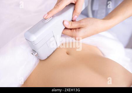 Porträt einer entspannten jungen Klientin, die eine SMAS-Ultraschall-Gesichtsliftmassage erhält Stockfoto