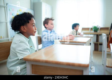 Die Schüler lernen und lernen in einem Klassenzimmer, in dem die Jugendlichen sitzen und aufmerksam zuhören. Stockfoto