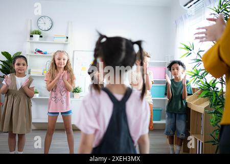 Lehrer und Schüler, Beifall, um einem Schüler in der Klasse zu gratulieren. Stockfoto