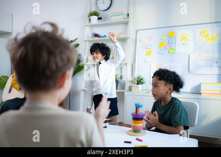 Im Unterricht singen Lehrer und Schüler zusammen, und die Jungs tanzen glücklich. Stockfoto