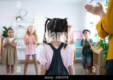 Lehrer und Schüler, Beifall, um einem Schüler in der Klasse zu gratulieren. Stockfoto