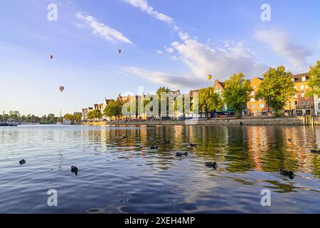 Die Altstadt von Lübeck, Deutschland mit Enten im Fluss und Ballons am Himmel Stockfoto