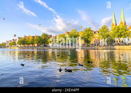 Die Altstadt von Lübeck, Deutschland mit Enten im Fluss und Ballons am Himmel Stockfoto