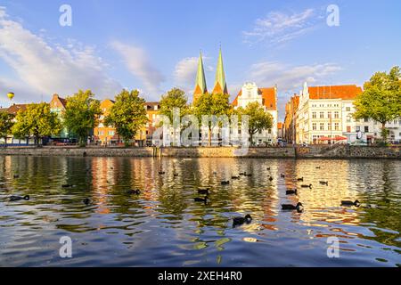 Die Altstadt von Lübeck, Deutschland mit Enten im Fluss und Ballons am Himmel Stockfoto