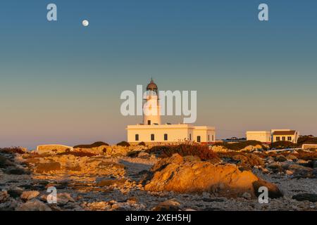 Blick auf den Leuchtturm Cap de Cavalleria auf Menorca bei Sonnenuntergang bei Vollmond Stockfoto