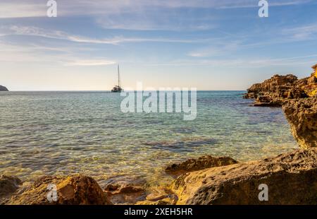 Blick auf eine idyllische Bucht bei es Cap Enderrocat im Süden Mallorcas mit einem Segelboot vor Anker Stockfoto