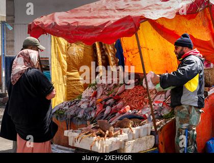 Fischer, die frischen Fisch und Meeresfrüchte auf dem Fischmarkt im Hafen von Essaouira verkaufen Stockfoto