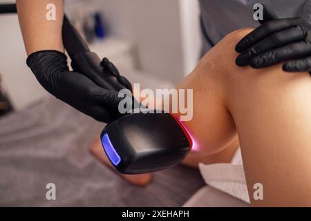 Schuss einer jungfit brünetten Klientin, die eine Laser-Haarentfernung am Körper erhält Stockfoto