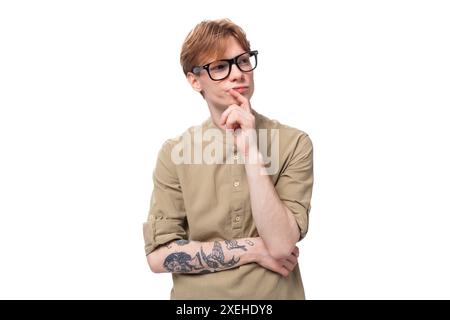 Junger kluger Mann mit roten kurzen Haaren in einem braunen Hemd auf einem Hintergrund mit Kopierraum Stockfoto