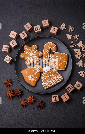 Schöne Weihnachtskomposition mit Kopierraum mit einer Inschrift in Holzwürfeln auf schwarzem Betonhintergrund Stockfoto