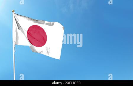 Japan-Flagge am bewölkten Himmel. Im Himmel winken Stockfoto