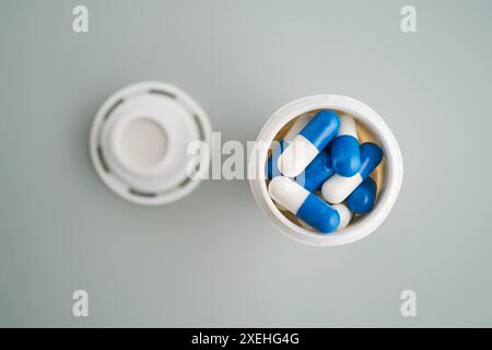 Blaue und weiße Kapseln in einem Glas in Nahaufnahme. Stockfoto