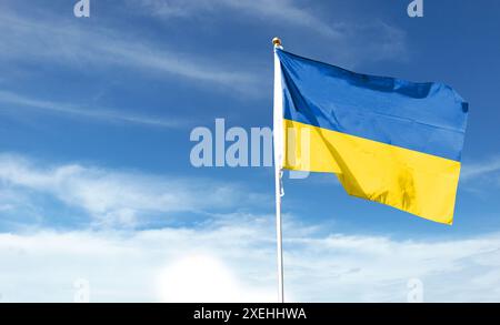 Ukrainische Flagge am bewölkten Himmel. Fliegen in den Himmel Stockfoto