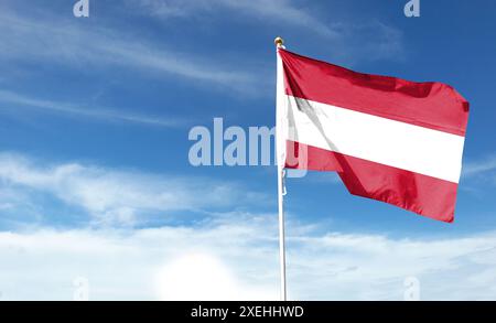 Österreichische Flagge am bewölkten Himmel. Fliegen Sie in den Himmel Stockfoto