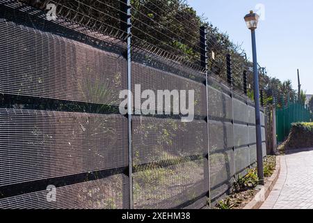 Sicherheit elektrifizierte Zäune schwarze und grüne Strukturen an der Grundstücksgrenze im Freien Nahaufnahme. Stockfoto