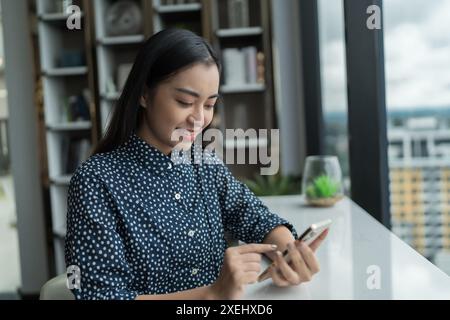 Asiatische Frau, die mobile Süchtige smartphoneÂ benutzt, um Zeit mit Nachrichten Social Media Handytechnologie E-Commerce-Conceep zu verbringen Stockfoto