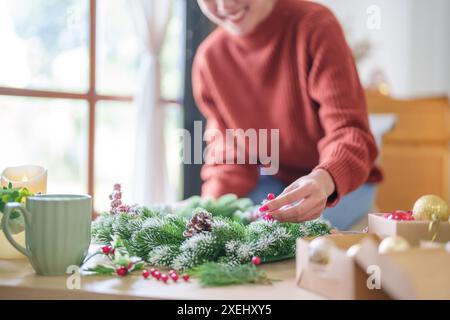 Frau, die Mistelkranz macht Weihnachtskranz Dekoration mit handgemachten DIY Winter Grün Blumenhändler Hände machen Weihnachtswrea Stockfoto