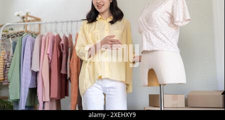 Young Asian girlÂ Online-Beratung mit Stylist Designer Online-Videokurs oder Schulung von stilvoller Kleidung an Kleiderbügeln c Stockfoto