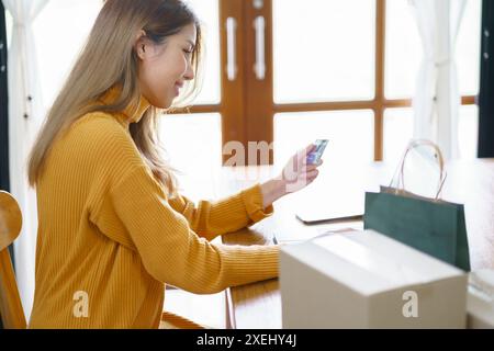 Frau shoppingÂ auf Laptop mit Kreditkarte für Internet Online-E-Commerce-Einkaufen Geld ausgeben Online-Einkaufen Handy-Telefon Stockfoto