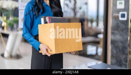 Job beenden asiatische Geschäftsfrau, die Kündigungsschreiben sendet und Zeug packt, Depression zurücktritt oder Geschäftskarton in sich trägt Stockfoto