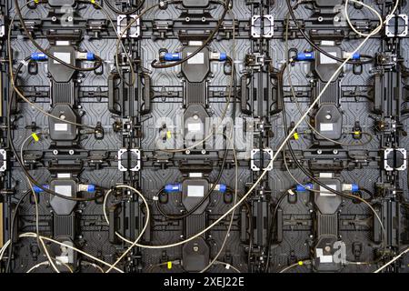 Textur der hinteren Ansichtsfelder. Stromeingangs- und Ausgangsleitung sowie Dateneingangs- und -Ausgangsstecker. Digitaler elektronischer Bildschirm. Rückseite des großen LED-Bildschirms Stockfoto