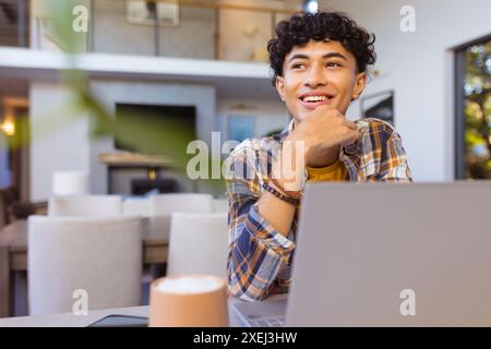 Lächelnder Teenager mit Laptop zu Hause, entspannte Momente, Kopierraum Stockfoto