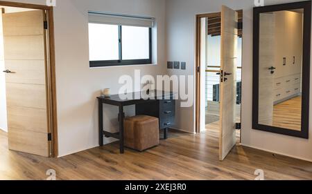 Moderne Inneneinrichtung mit Schreibtisch, Stuhl und großem Spiegel im Schlafzimmer, Kopierbereich Stockfoto