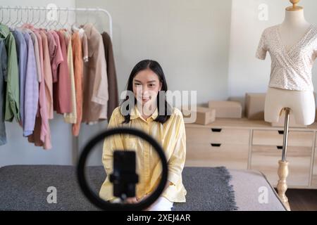 Young Asian girlÂ Online-Beratung mit Stylist Designer Online-Videokurs oder Schulung von stilvoller Kleidung an Kleiderbügeln c Stockfoto