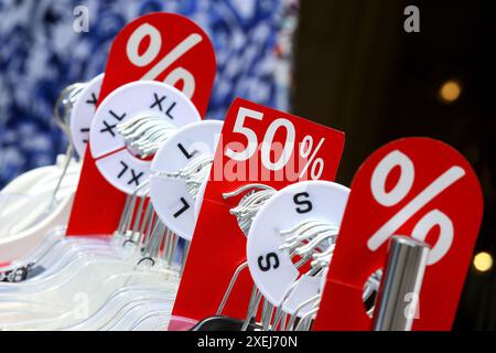 VERKAUF - Prozentzeichen - 50 Prozent - Sommer-Räumung - Rabattschlacht im Einzelhandel - 22.06.2024, Berlin, Deutschland, DEU, DE, DE, DE, Deutschland - Sommer-Sale in vielen Geschäften und Kaufhäusern mit großen Preisnachlässen. Aktionsschild an einem Kleiderständer Textilständer eines Bekleidungsgeschäftes. Zahlreicher Händler reduziert Ihre eingekaufte Sommerware, um Platz für neue Ware auch Winterware zu schaffen. Auf der Kleiderstange befinden sich Größenringe mit Kennzeichnungen der Konfektionsgrößen. *** VERKAUFSPROZENTSATZ Zeichen 50 Prozent Sommerfreigabe Discount Battle im Einzelhandel 22 06 2024, Berlin, G Stockfoto