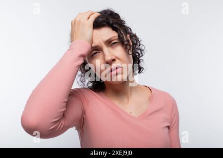 Porträt einer aufgeregten lockigen Frau mit einem kurzen Haarschnitt in einer rosa Bluse Stockfoto