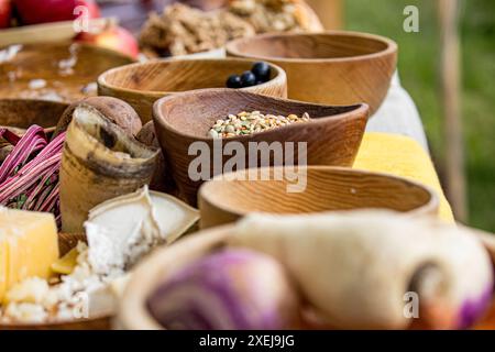 Rustikale Szene mit Samen in einer alten Holzschale, auf einem Tisch neben anderen Holzschalen voller Gemüse Stockfoto