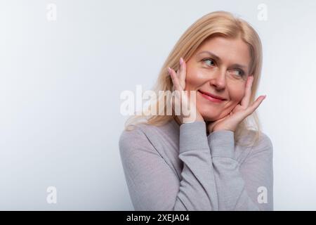 Eine europäische Frau mit blonden Haaren verhält sich im Studio bescheiden Stockfoto