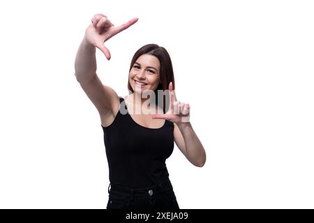 Junge schlanke Brünette, die ein enges T-Shirt auf weißem Hintergrund trägt Stockfoto
