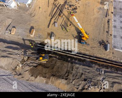Bauarbeiten an der Küste. Schwere Maschinen arbeiten, um das Fundament vor Wasser und Sturmwellen zu stärken. Blick von der Drohne. Stockfoto