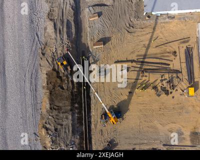 Bauarbeiten an der Küste. Schwere Maschinen arbeiten, um das Fundament vor Wasser und Sturmwellen zu stärken. Blick von der Drohne. Stockfoto