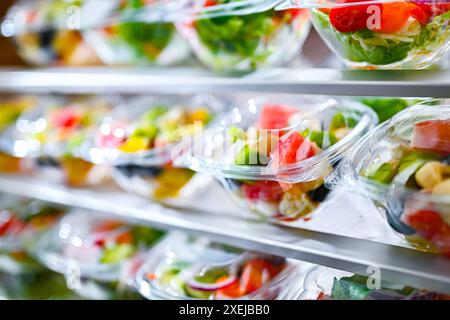 Plastikboxen mit vorverpackten Obst- und Gemüsesalaten Stockfoto