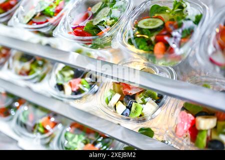 Plastikboxen mit vorverpackten Obst- und Gemüsesalaten Stockfoto