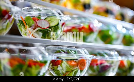 Plastikboxen mit vorverpackten Obst- und Gemüsesalaten Stockfoto